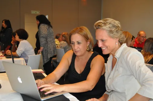 Profesor de Contabilidad Profesora de contabilidad explicando a una alumna en la laptop